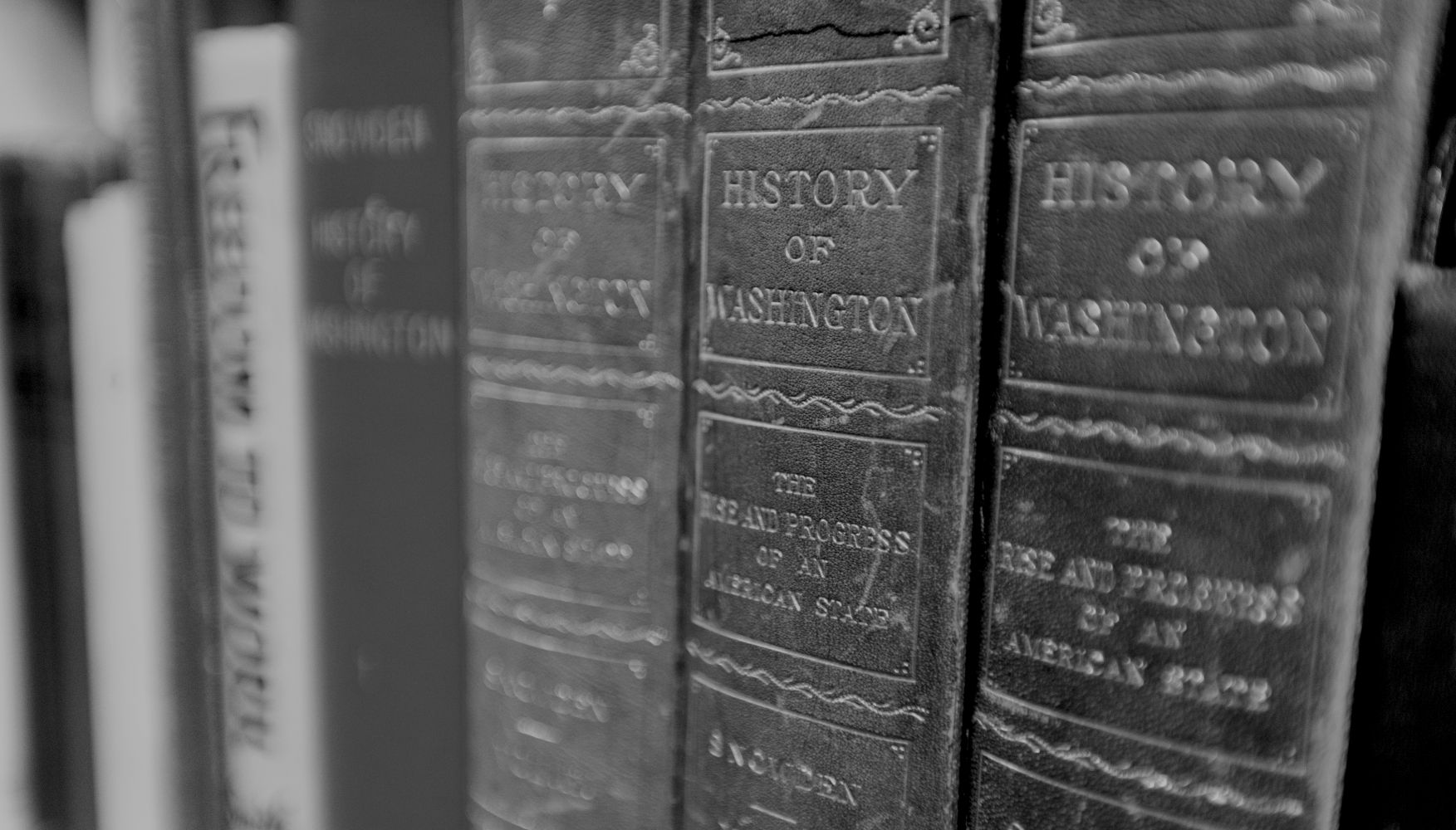 Spines of leather-bound books on the History of Washington in UW's Suzzallo Library.