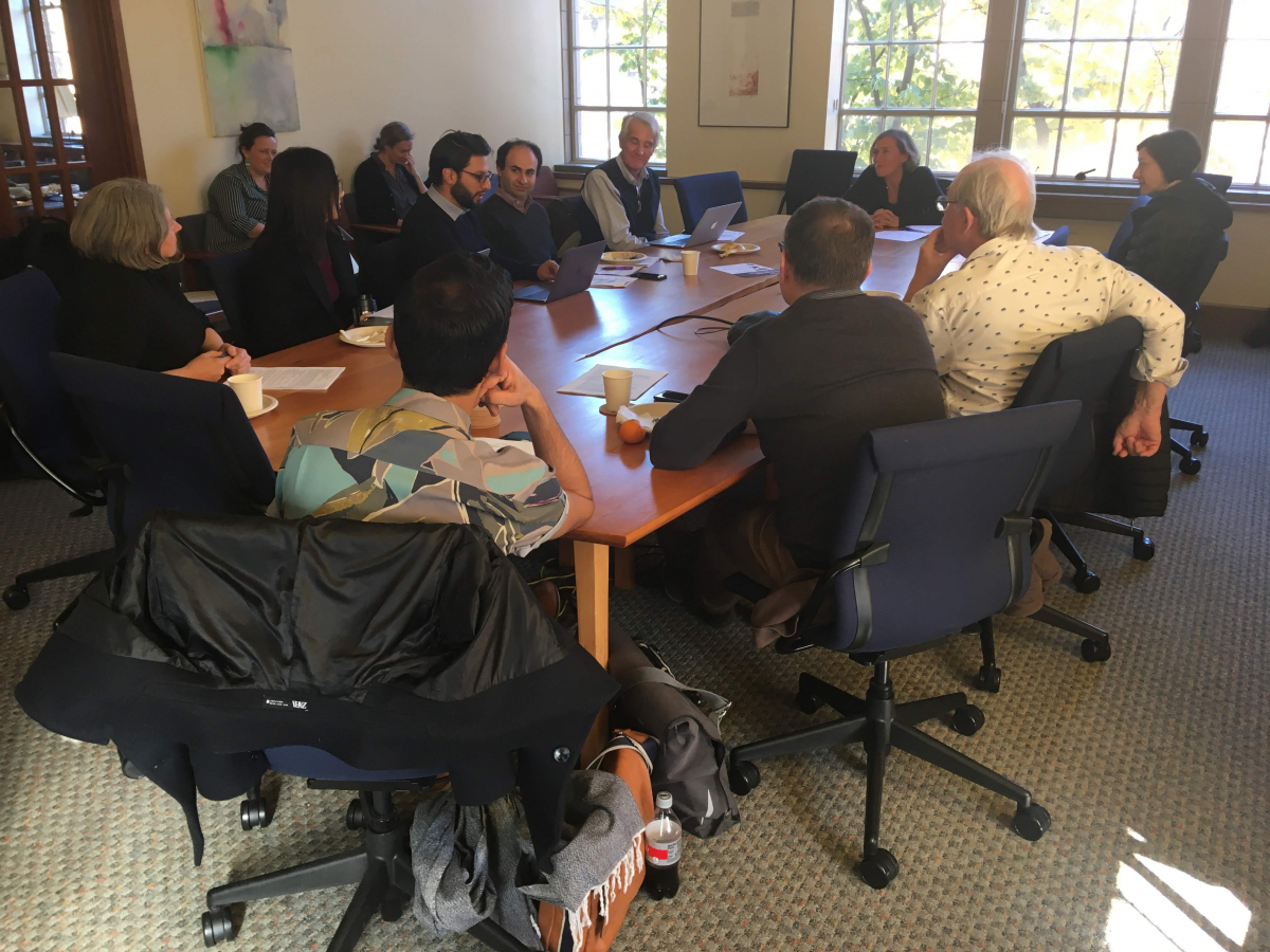 Professor Glaser and other scholars sitting at a meeting around a large table