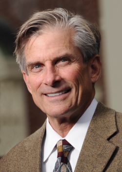 Portrait of William D. Adams wearing a tan suit, white shirt, and tie.