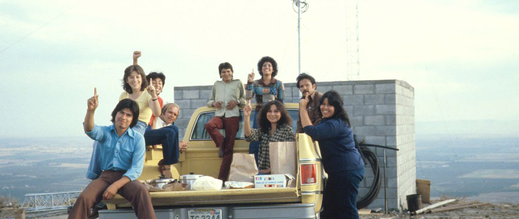 Radio KDNA workers sitting on back of truck near building site of KDNA tower