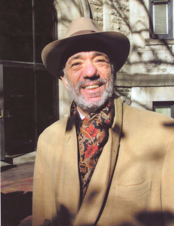 Lenn Goodman looks into the camera while wearing a brimmed hat and tan jacket.