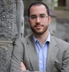 Portrait of Dan Berger leaning against a brick wall