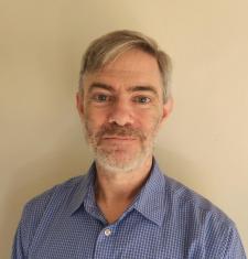 Eric Johnson smiling wearing a blue shirt