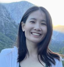 Jingsi Shen stands outside with mountains in the background.