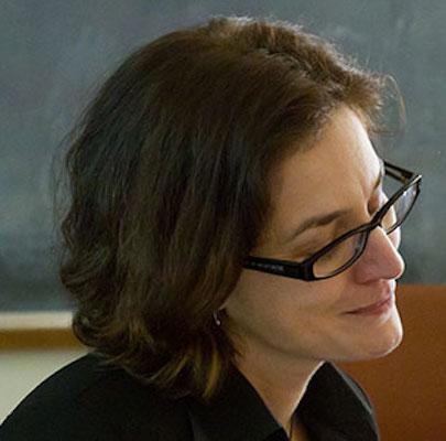 side portrait of Gillian Harkins in front of a blackboard