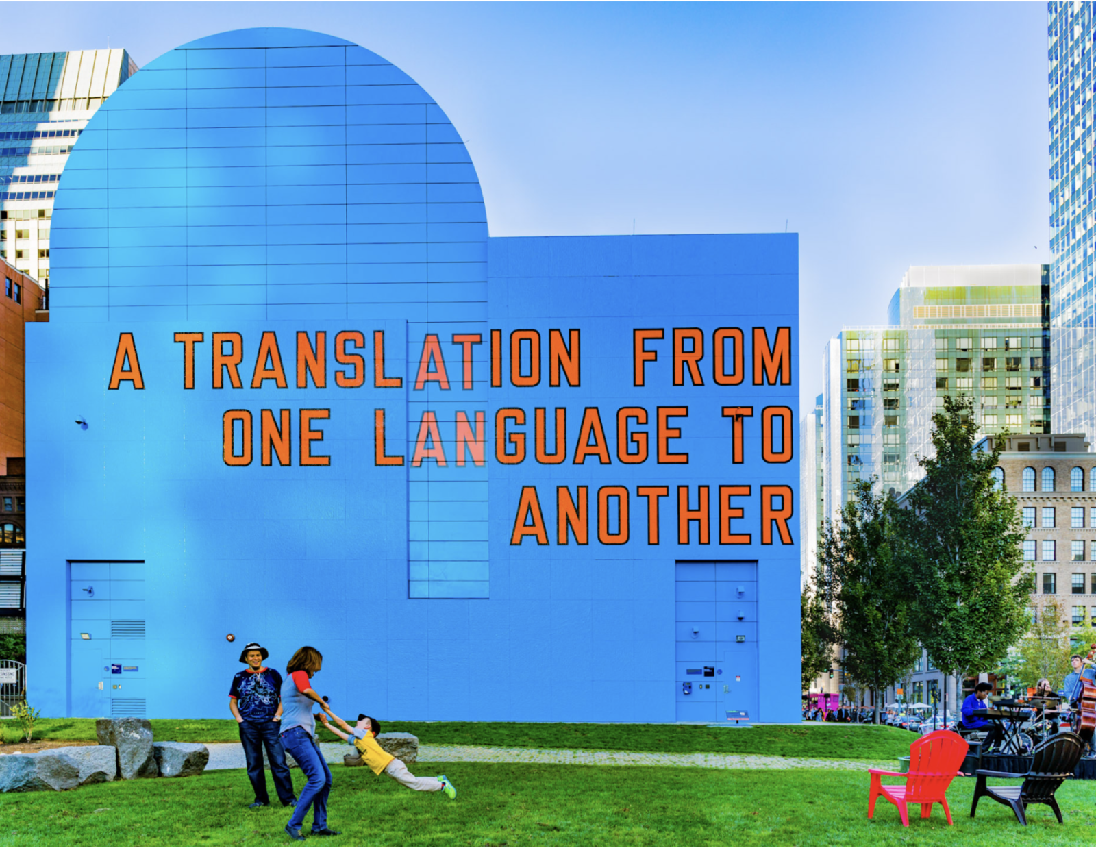 "A Translation From One Language to Another" is in orange text on a building painted bright blue. City skyscrapers are behind the building and people play in a grassy area in front of the building. The skies are sunny and blue.