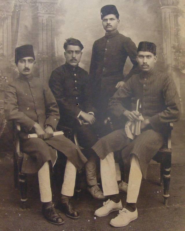 Four South Asian men in the 1930s wearing fezzes and sherwanis