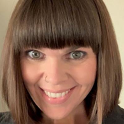 A close-up image of Jennifer Smith against a beige background.