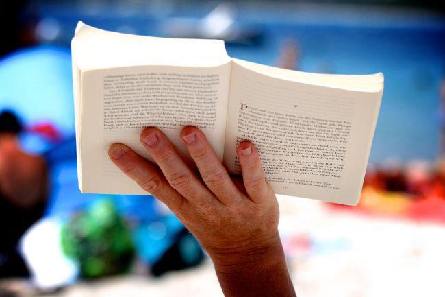 Book being held up with one hand.