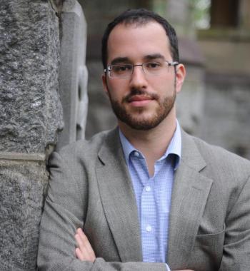 Portrait of Dan Berger leaning against a brick wall