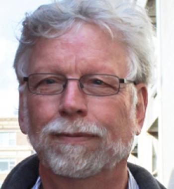James Gregory stands outside wearing glasses.