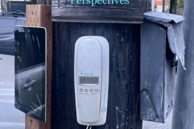 Various technologies like a landline phone and an iPad are nailed to a telephone pole. On the telephone pole, there is a sign that reads "Platform Perspectives"