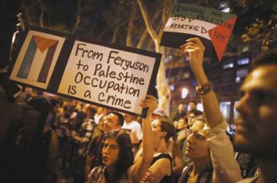 A group of protesters hold signs.