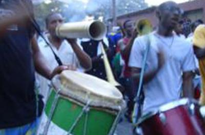 People playing drums and instruments in the streets of a Caribbean city