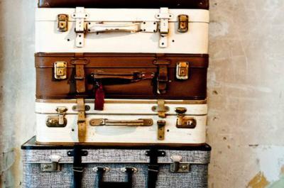 Suitcases stacked against a cream colored wall