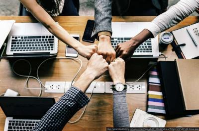 Fist bump in the center of a table