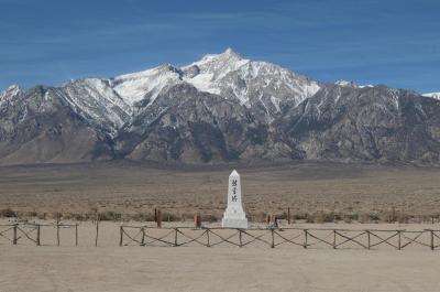 still from Manzanar Diverted: shows a japanese white stone monument in a plain in front of mountains