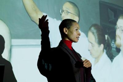 Scholar presenting in front of a projector