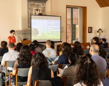 Speaker at podium facing audience members