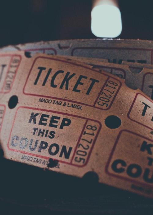 A spool of movie tickets on a black background.