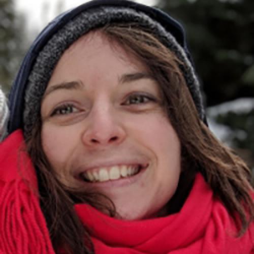 A close up portrait of Céline Maillard wearing a hat and red scarf.