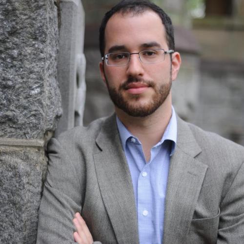 Portrait of Dan Berger leaning against a brick wall