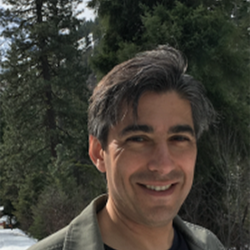 Geoffrey Turnovsky stands outside wearing a black shirt and grey jacket.