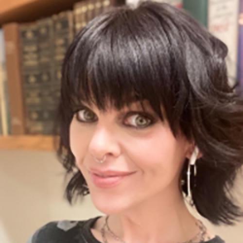 A close-up portrait of Jennifer Smith standing in front of a bookcase.