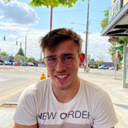 Photo of Alec Fisher in front of a palm tree.