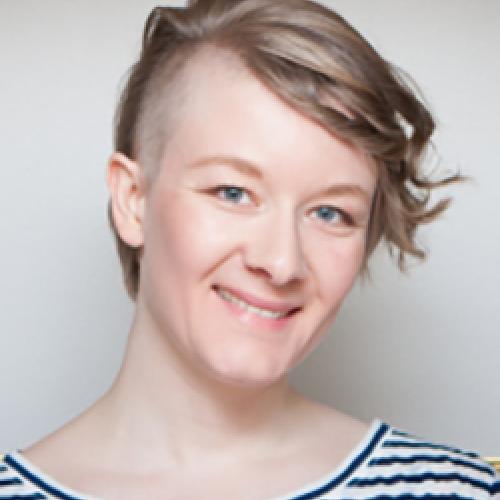 Lise Lalonde wears a striped shirt while standing in front of a white wall.