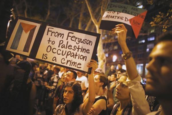 A group of protesters hold signs.