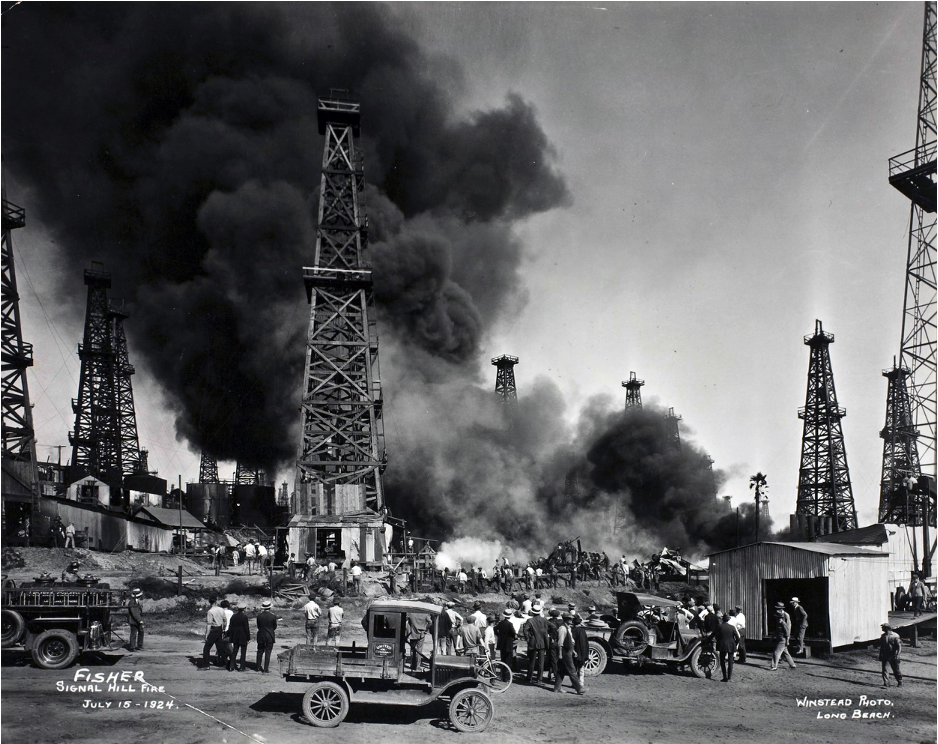  Crowds watching oil fields accident, smoke coming out of oil rigs. Circa 1920