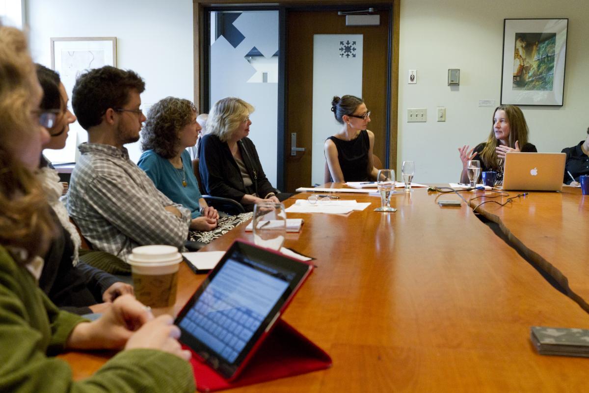 scholars discussing a topic around the main Simpson Center conference room table