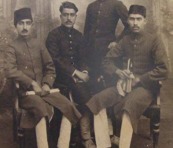 Four South Asian men in the 1930s wearing fezzes and sherwanis