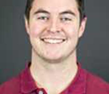 A close-up image of Kyle Kubler wearing a red shirt against a grey background.