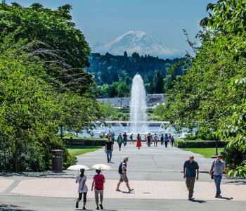 The UW campus in the summer, with the Drumheller Fountain and Mount Rainier visible in the distance