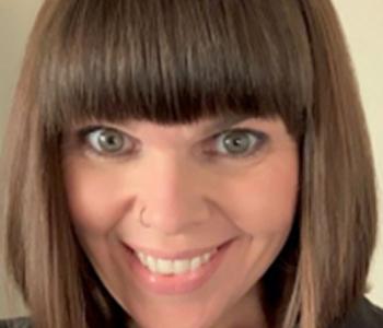 A close-up image of Jennifer Smith against a beige background.