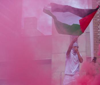 Palestinian flag behind pink gas (Nick Lachance/NurPhoto via Getty Images)