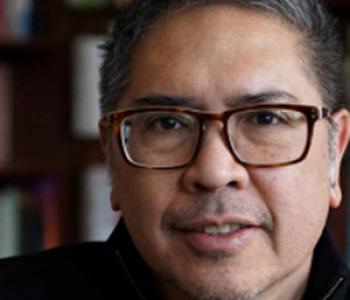 A close-up image of Vicente Rafael wearing glasses and a dark shirt in front of a bookcase.