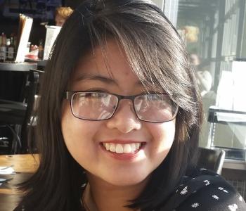 A portrait of Anna Nguyen wearing glasses.