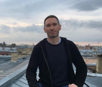 Brendan McElmeel stands on a rooftop wearing a dark shirt.