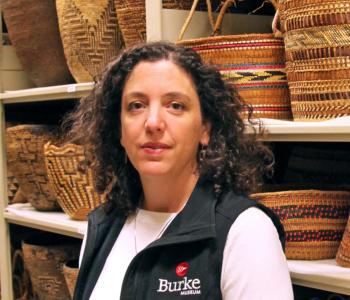 Katie Bunn-Marcuse stands in front of shelves holding baskets.