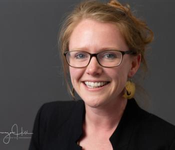 Sarah Inman professional photo in a black blazer smiling at the camera