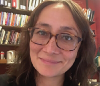 Portrait of Candice Rai sitting in front of a bookcase.