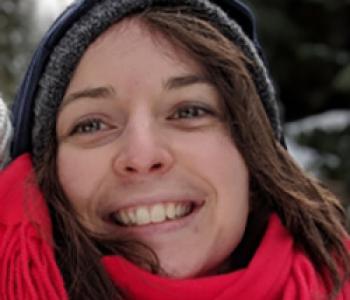 A close up portrait of Céline Maillard wearing a hat and red scarf.