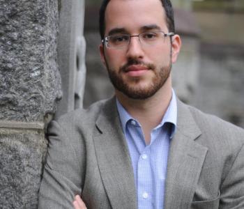 Portrait of Dan Berger leaning against a brick wall