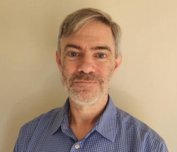 Eric Johnson smiling wearing a blue shirt