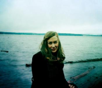 Erin Gilbert stands in front of a body of water.