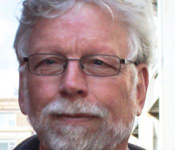 James Gregory stands outside wearing glasses.