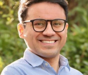 Jesús Hidalgo stands outside while wearing glasses and a blue collared shirt.